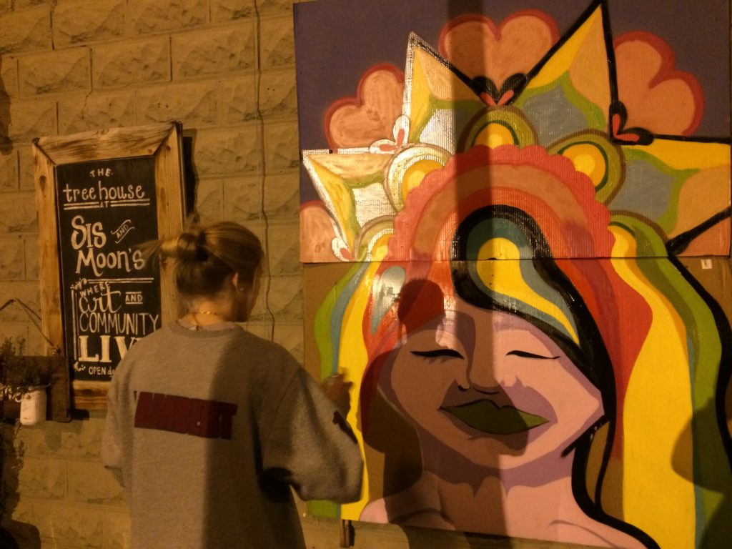 Kali working on neck and hair of graffiti style painting